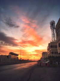 Road by street against sky during sunset