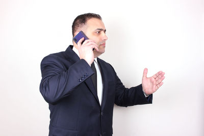 Young man using smart phone against white background