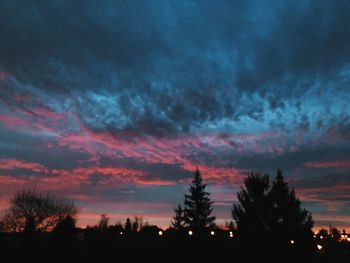 Silhouette trees against sky at night