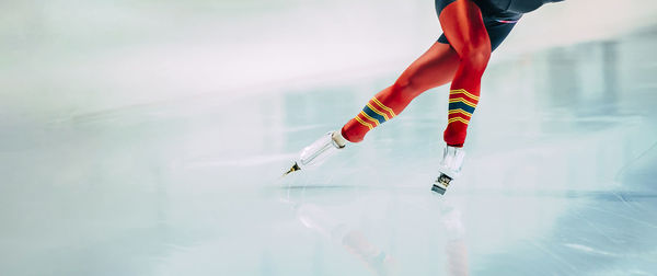 Low section of person ice skating on rink
