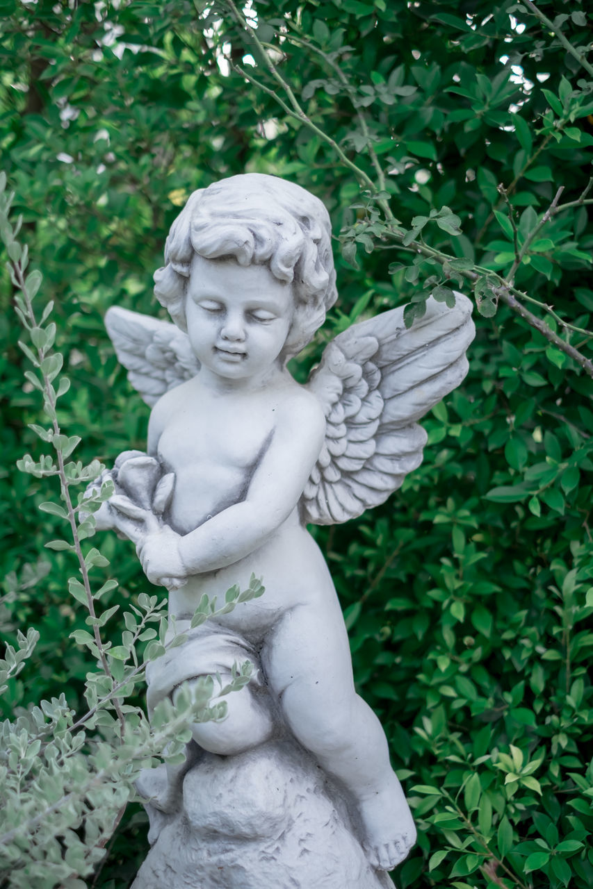 STATUE OF ANGEL AGAINST PLANTS