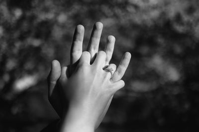 Close-up of woman holding man's hand over blurred background