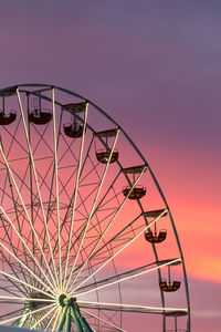 Low angle view of ferris wheel against sky during sunset