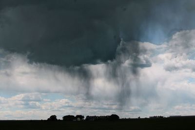 Silhouette landscape against cloudy sky
