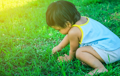High angle view of little girl sitting on grassy field