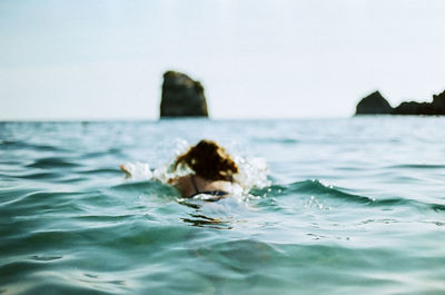 Portrait of man swimming in sea against clear sky