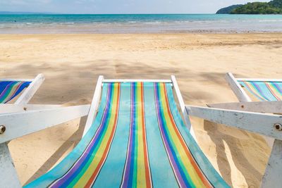 Close-up of deck chairs on beach