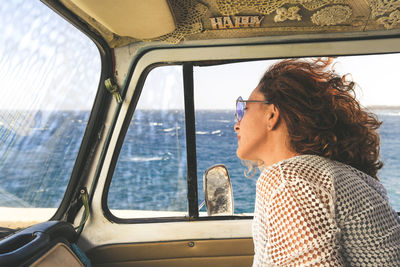Woman looking through vehicle window