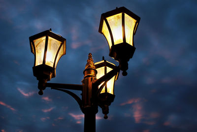 Low angle view of illuminated street light against sky