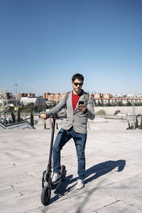 Full length portrait of young man against clear sky