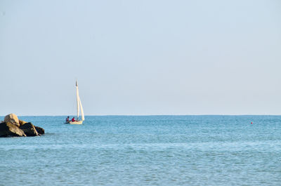 Sailboat in sea against clear sky