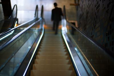 Blurred image of modern escalators staircase at shopping mall with vanishing escalators.