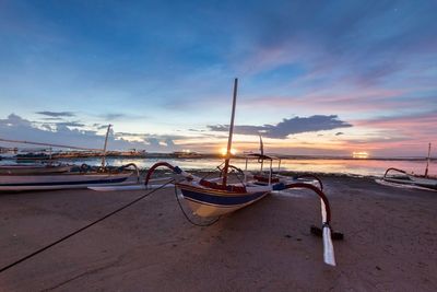 Boats in sea against cloudy sky