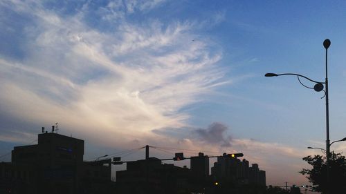 Silhouette buildings against cloudy sky