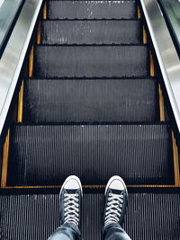 Low section of man standing on escalator