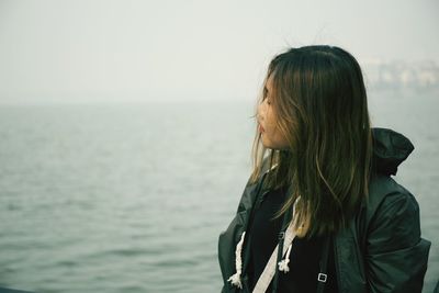 Woman looking at sea against sky