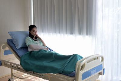 Young woman lying on bed at hospital