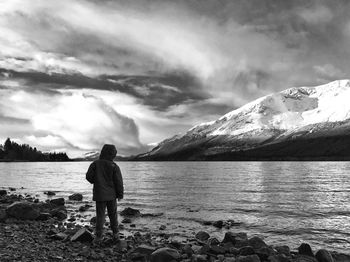 Rear view of woman standing on mountain against sky