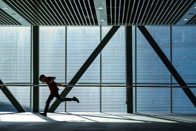 Full length side view of man walking in corridor