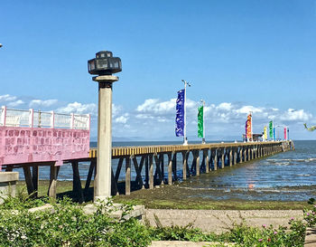 View of bridge over street against blue sky