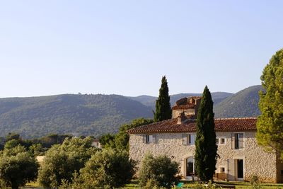 Houses by mountains against clear sky