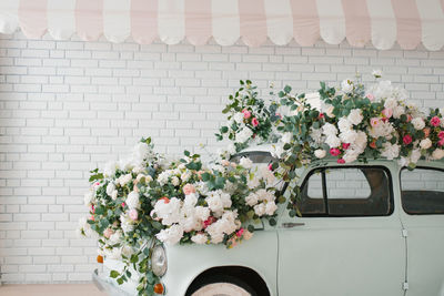 Retro mint car decorated with flowers in the photo zone in a romantic style for spring day