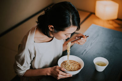 Woman sitting on table at home