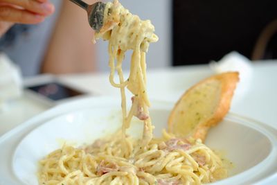 Close-up of person preparing food in plate