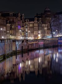 Illuminated buildings reflecting on lake at night