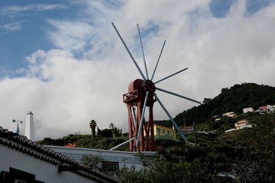 Low angle view of wind turbines against sky