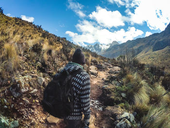 Rear view of man on mountain against sky