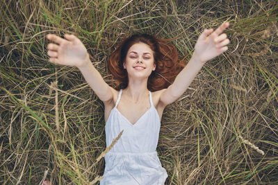 Young woman smiling while standing on field