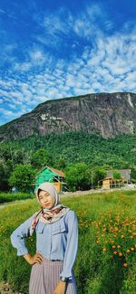 Woman standing on field against mountain