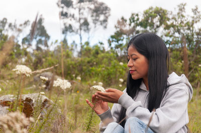 Young woman looking away while standing outdoors