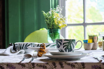 Crockery arranged on dinning table at home