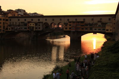 High angle view of people by arno river against ponte vecchio