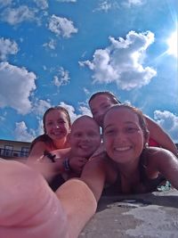 Low angle view of smiling boy against sky