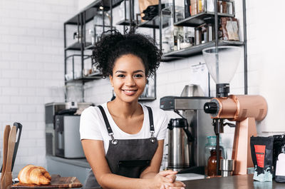 Portrait of young woman standing in cafe