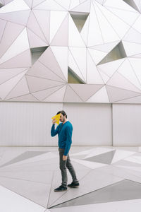 Full length of man standing against building