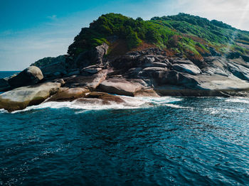 Rock formation in sea against sky