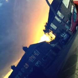 Low angle view of buildings against sky at sunset