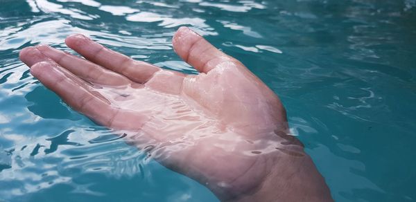 Low section of person legs in swimming pool