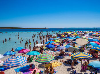 Group of people on beach against clear sky