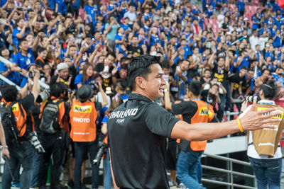 Group of people standing on soccer field