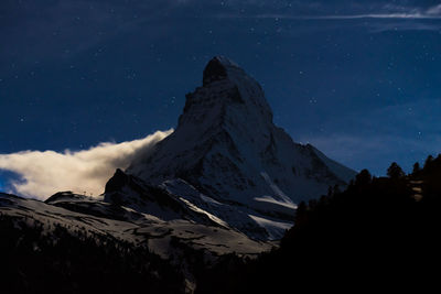 Scenic view of snowcapped mountains against sky at night