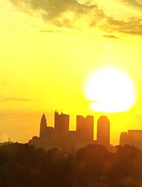 Silhouette cityscape against sky during sunset