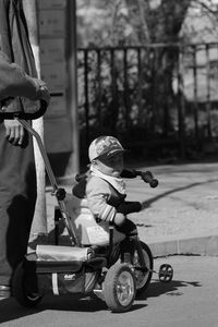 People with baby boy in carriage on street