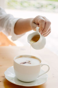 Close-up of pouring honey into coffee