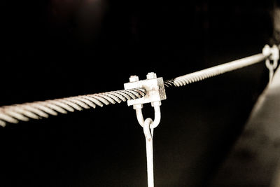 Close-up of rope on metal against black background