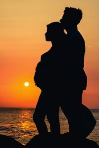 Silhouette couple at beach during sunset